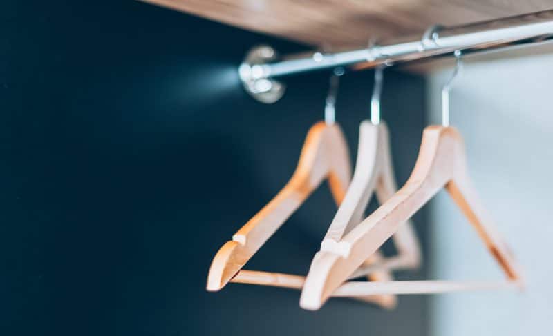 Tomma trähängare på skena i garderoben